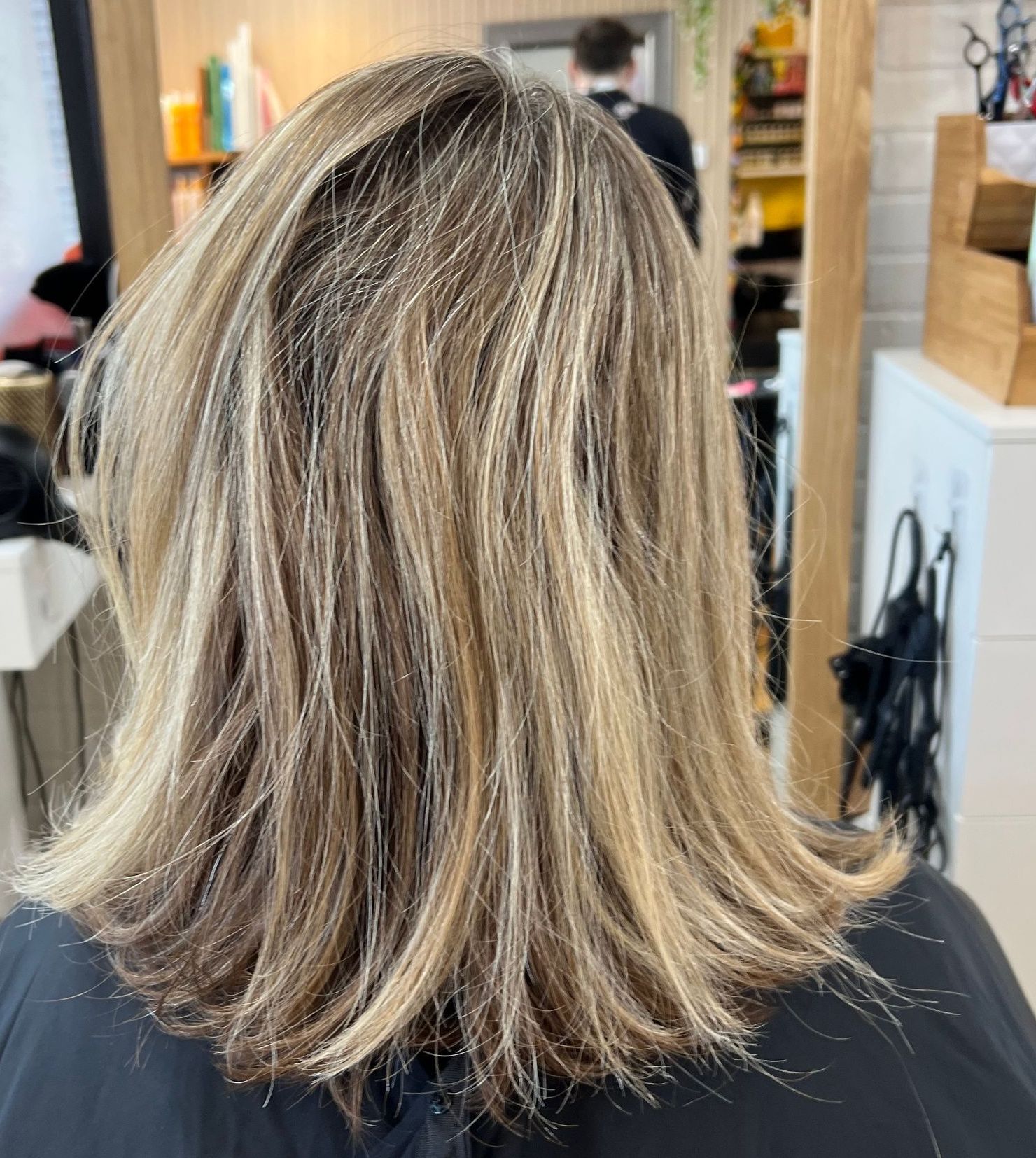 The back of a woman 's hair is shown in a salon.