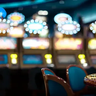 A blurry picture of a casino with a table and chairs in the foreground.
