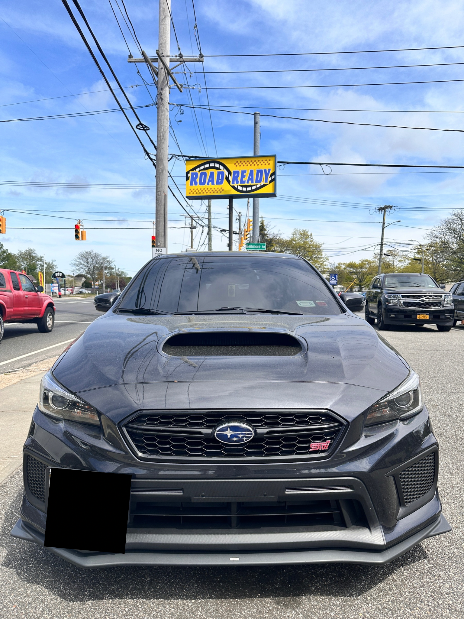 Gray Subaru WRX STI parked in front of a repair shop on a sunny day. | Road Ready