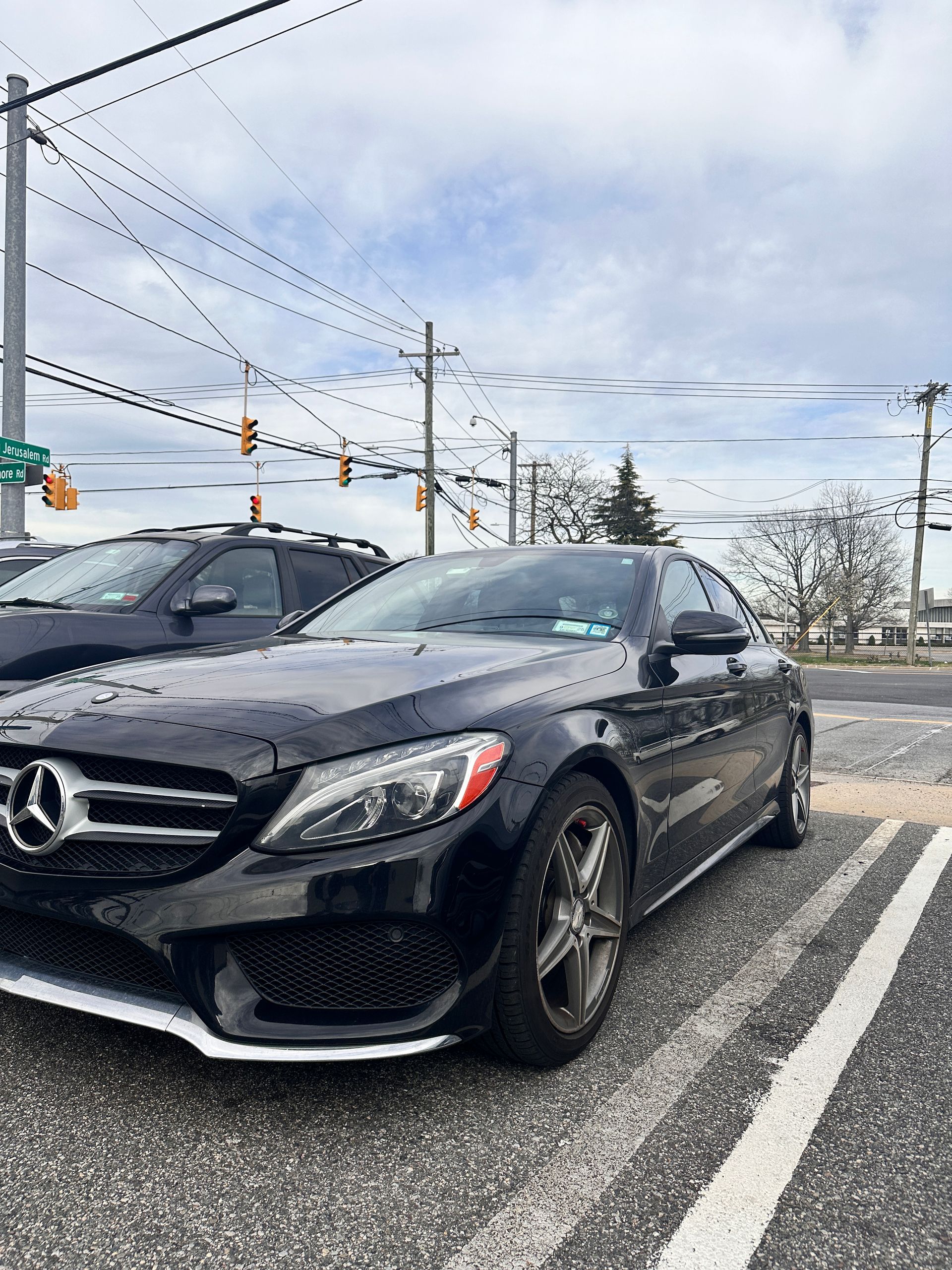 Black Mercedes-Benz sedan parked in a lot, cloudy sky overhead. | Road Ready