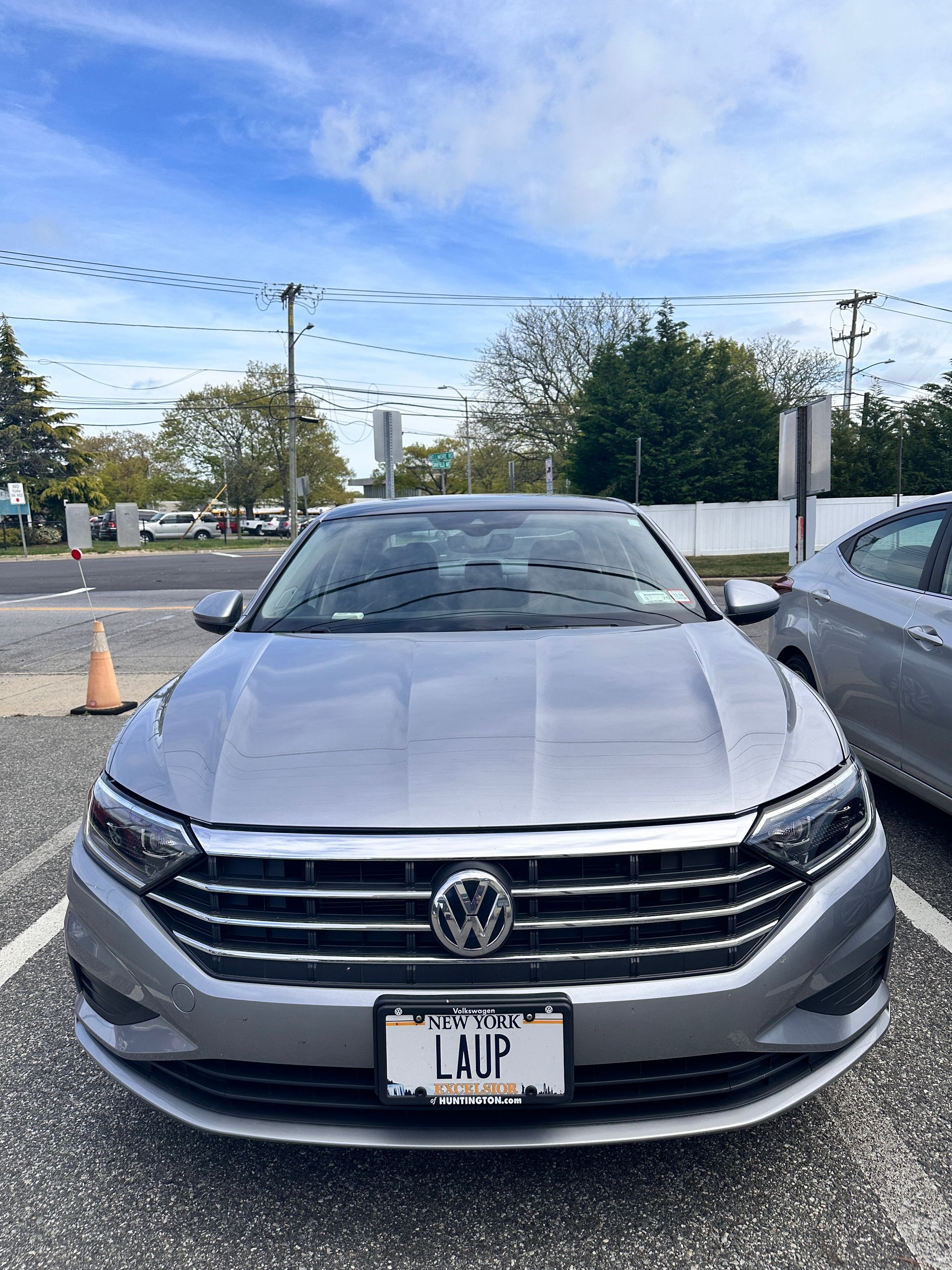 Silver Volkswagen sedan with LAUP license plate parked in a lot under a cloudy sky. | Road Ready