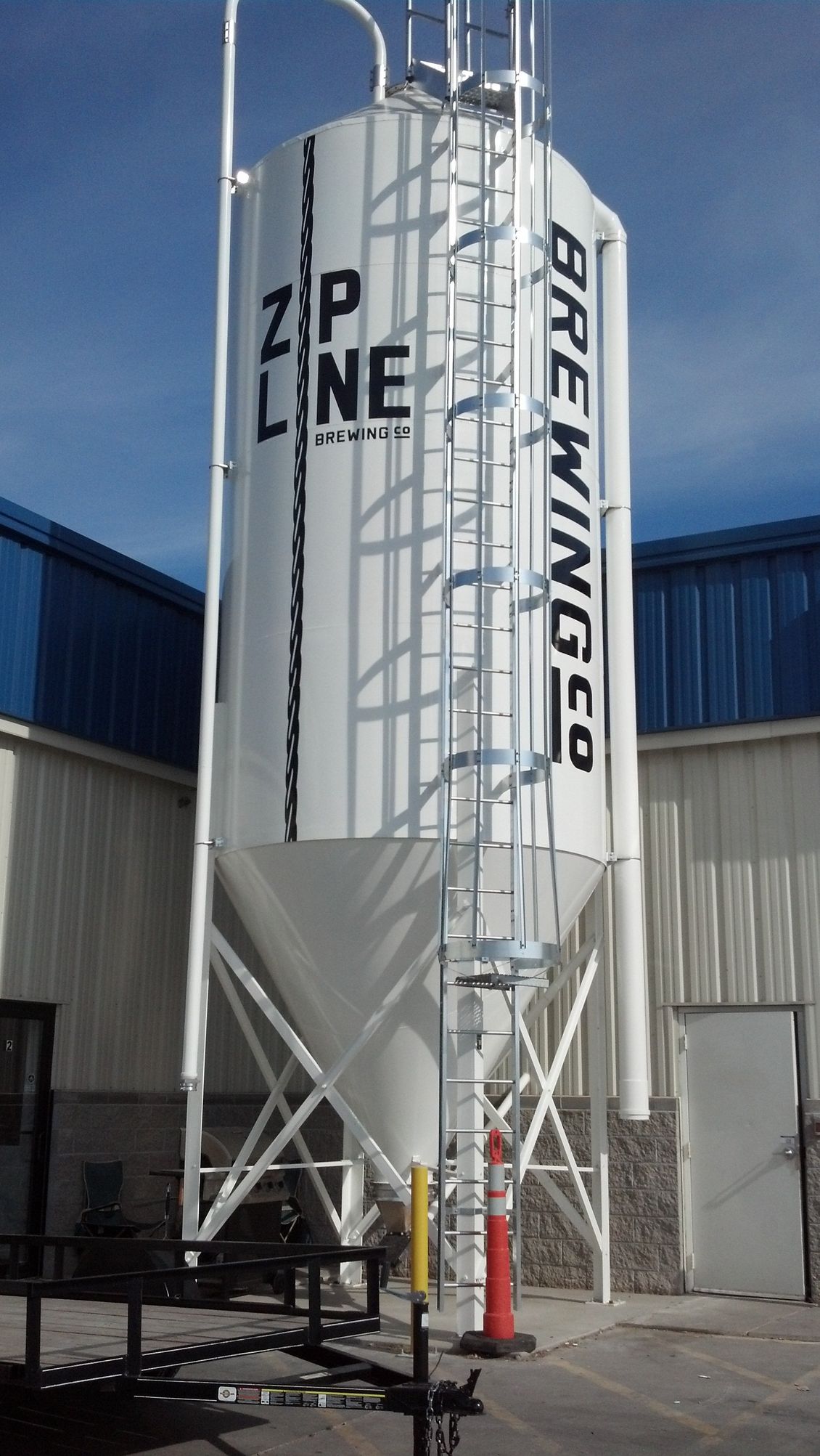 A large white silo that says brewing co on it