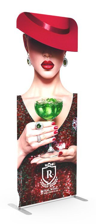 A woman in a red hat is holding a glass of green liquid.