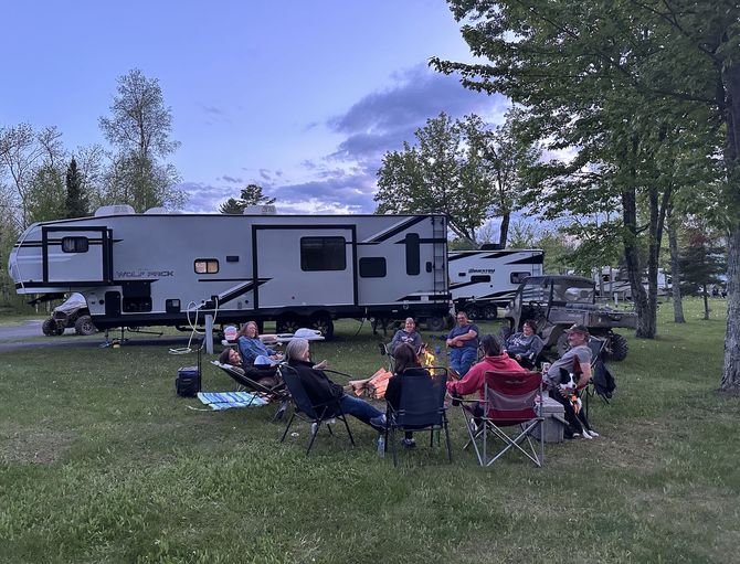 An image of people and RV on the Trails Inn Quadna RV Campground. An image of a family, RV & SxS on the Trails Inn Quadna Mountain RV Campground.