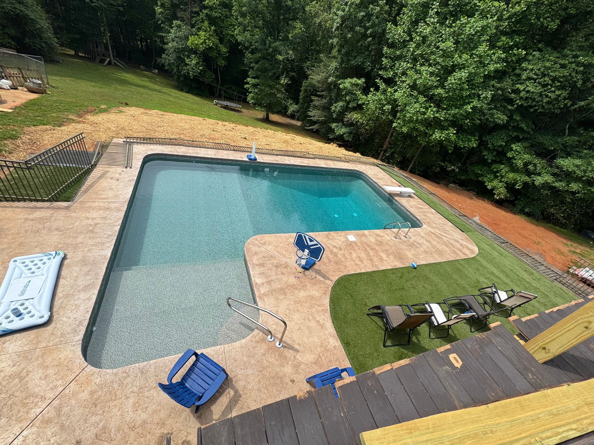 Stone water feature with three waterfalls flowing into a pool.