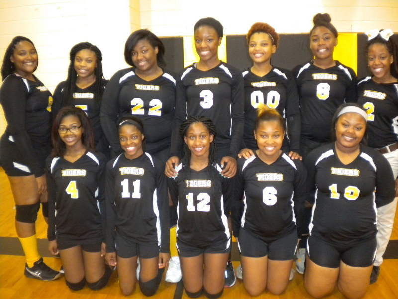a group of female volleyball players posing for a photo