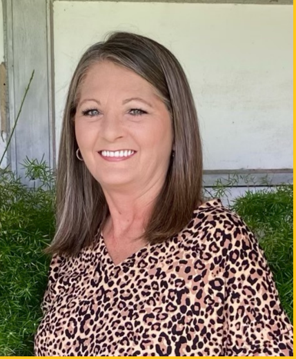 a woman in a leopard print shirt is smiling for the camera .