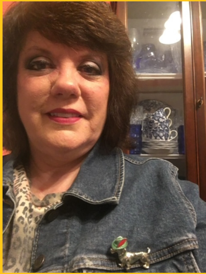 a woman wearing a denim jacket and a dachshund pin