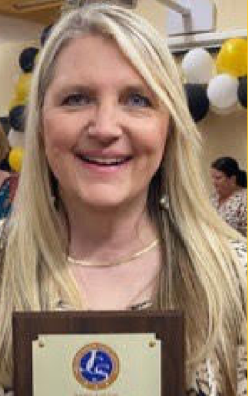 a woman is holding a plaque and smiling .