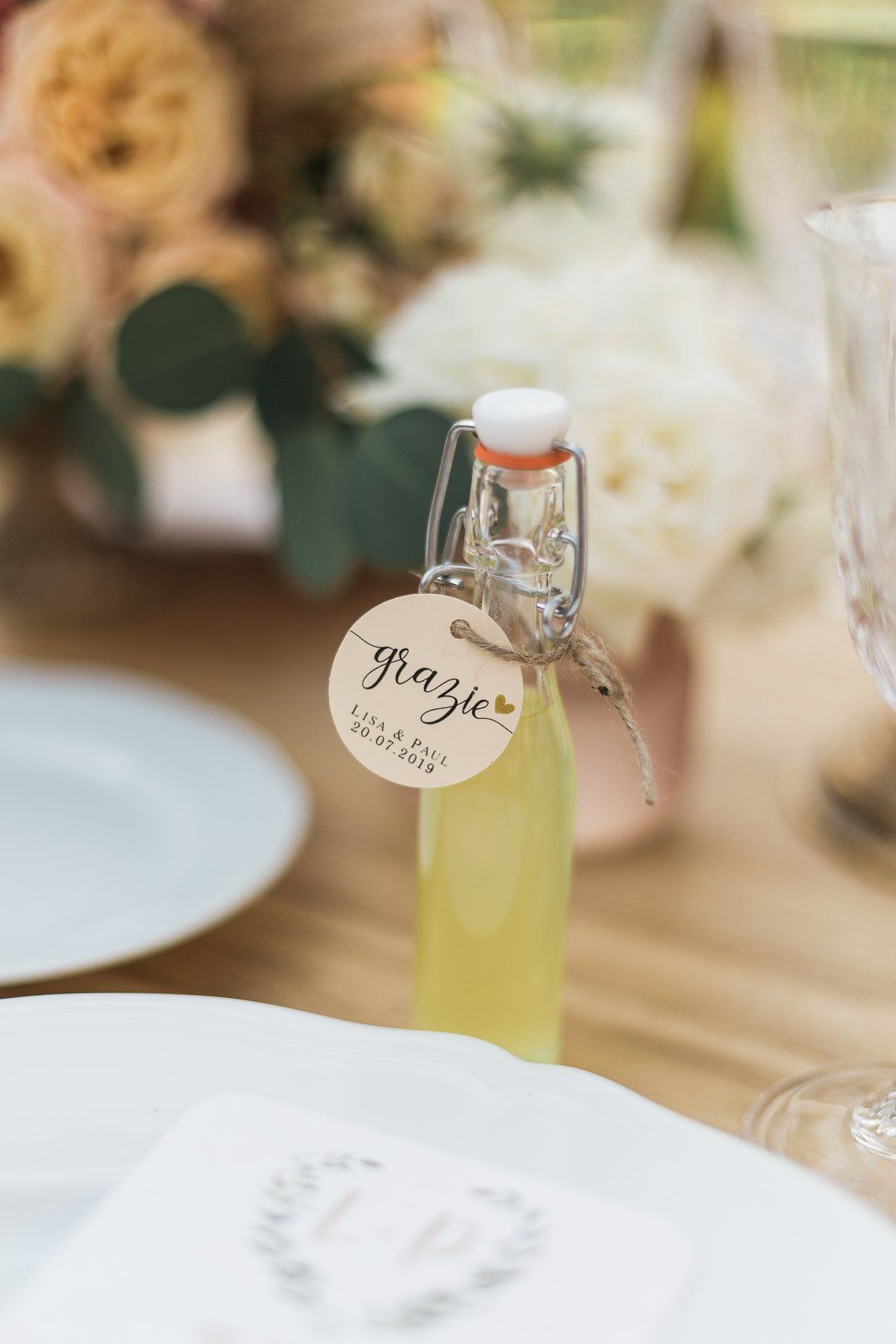 A small bottle with a tag on it is sitting on a table.