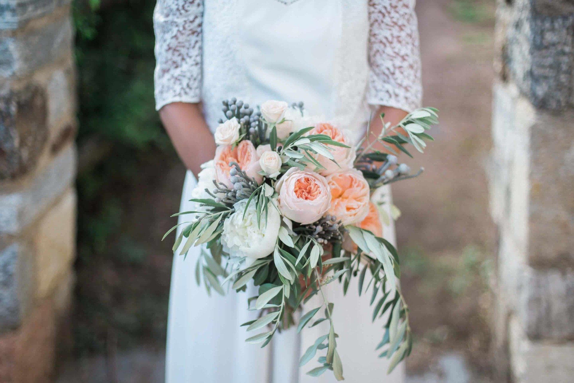 A bride in a white dress is holding a bouquet of flowers.