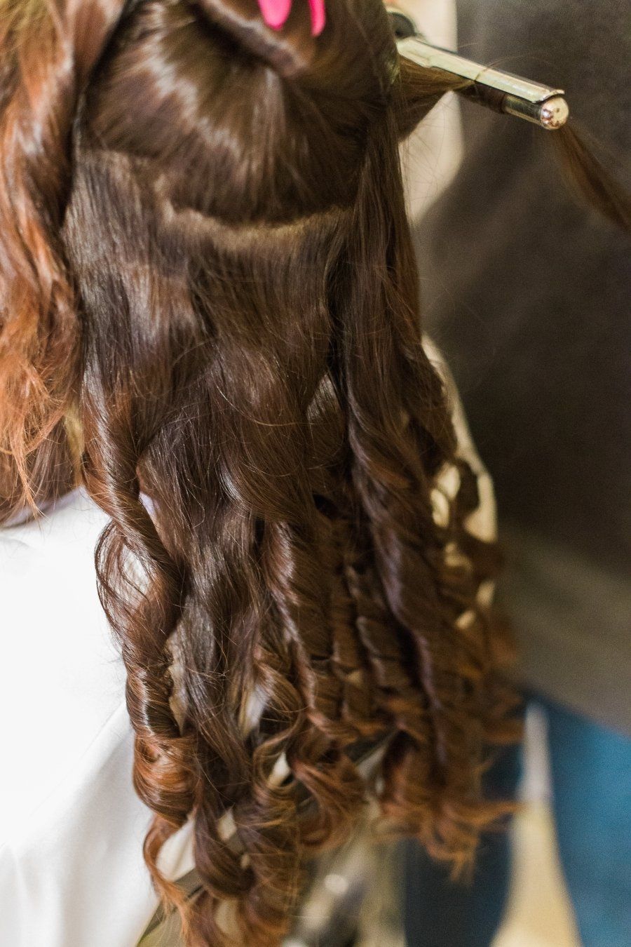 A woman is getting her hair done by a hairdresser.