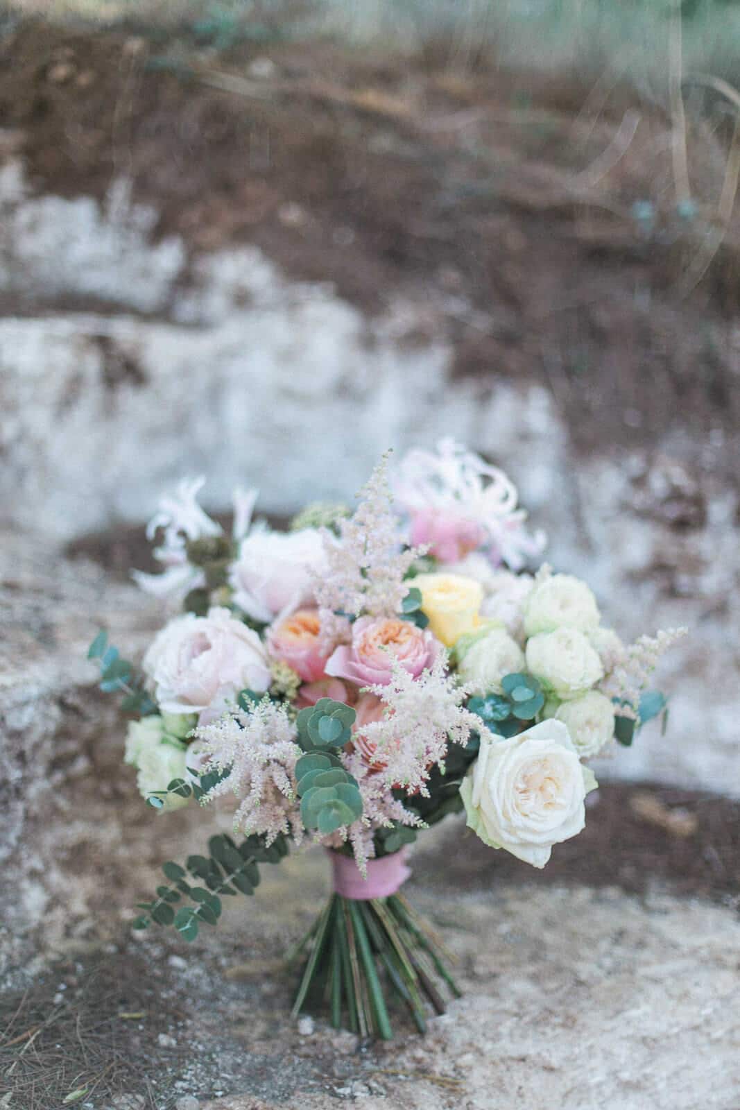 A bouquet of flowers is sitting on a rock.