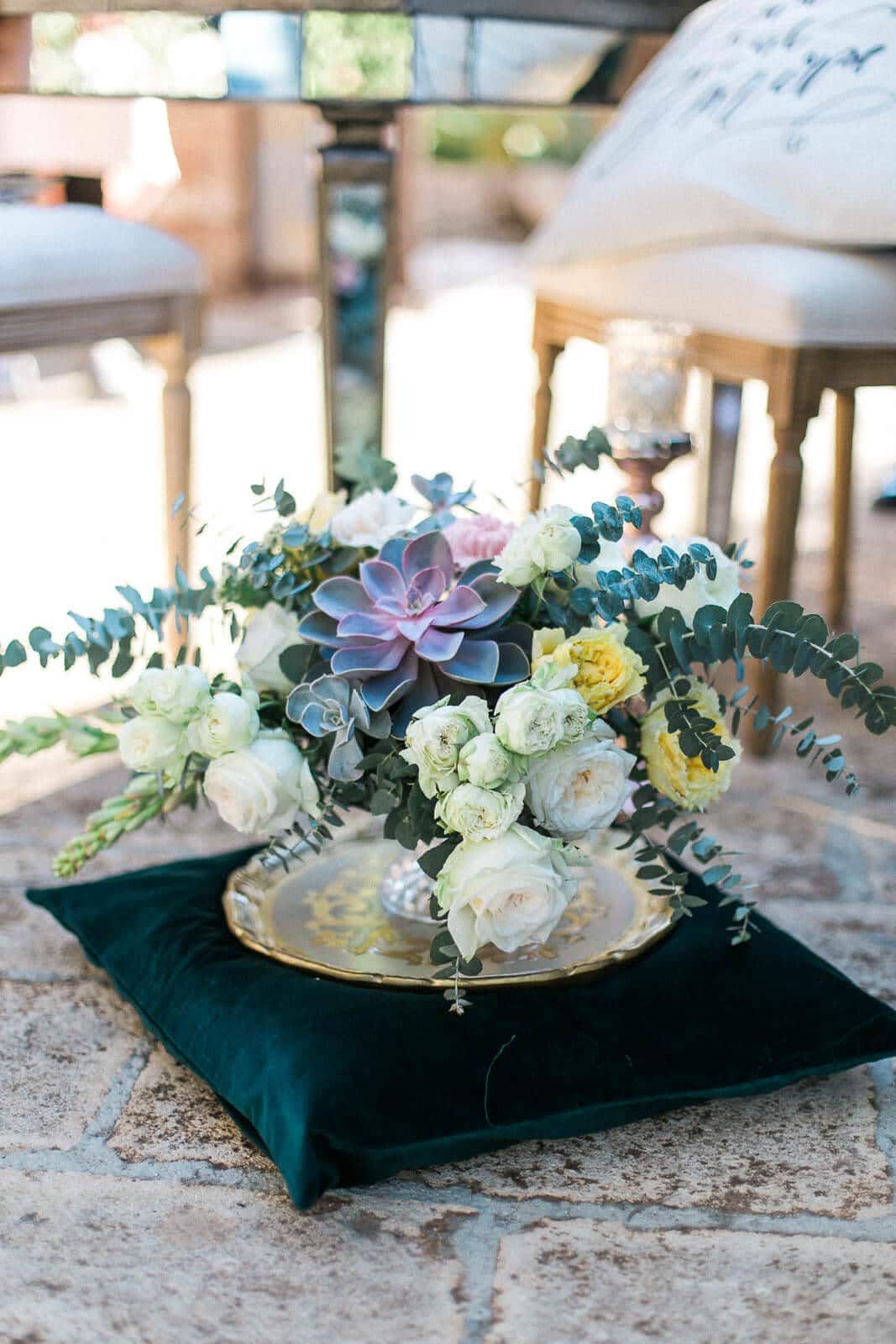 A vase filled with flowers is sitting on a pillow.