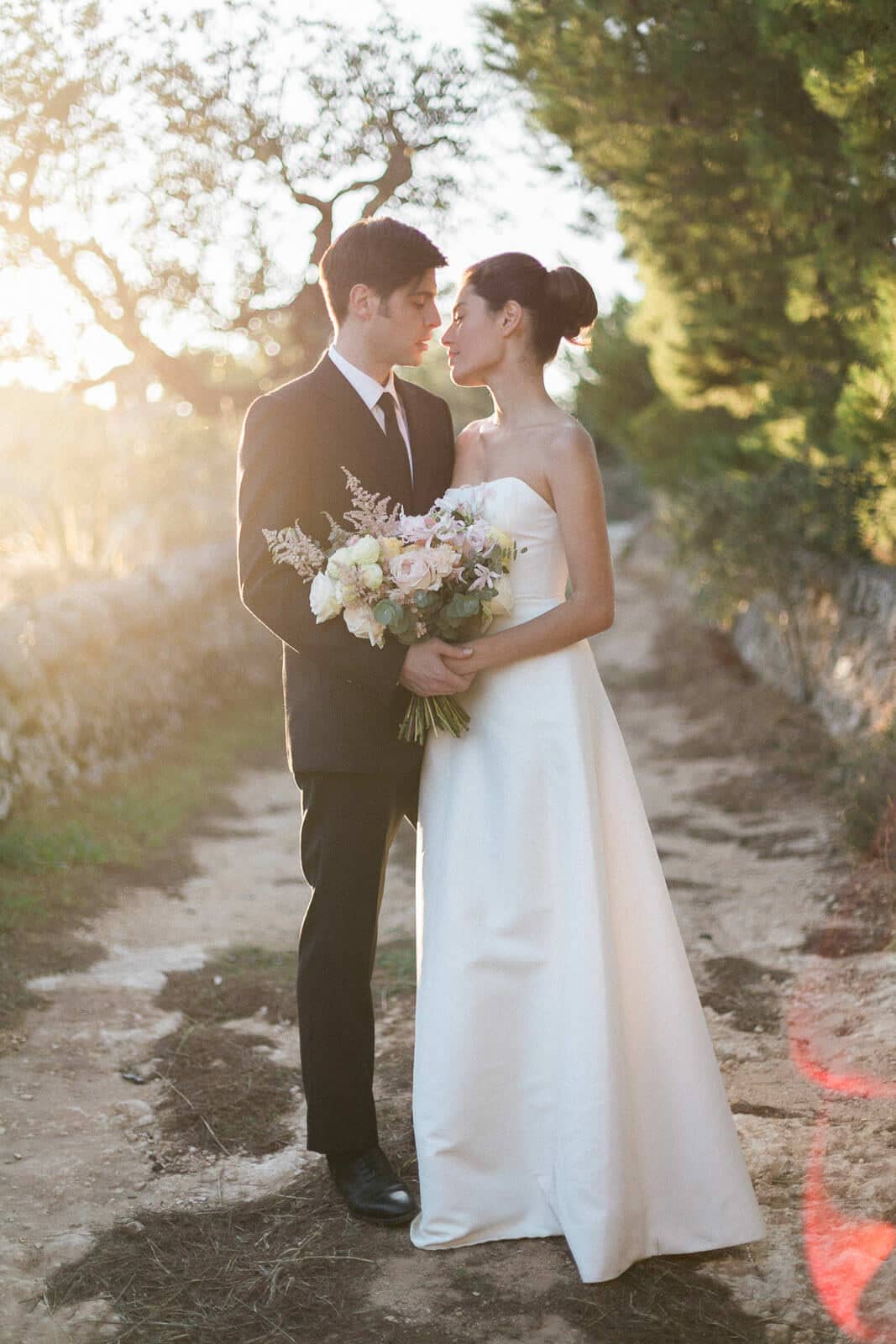 A bride and groom are standing next to each other and looking at each other.