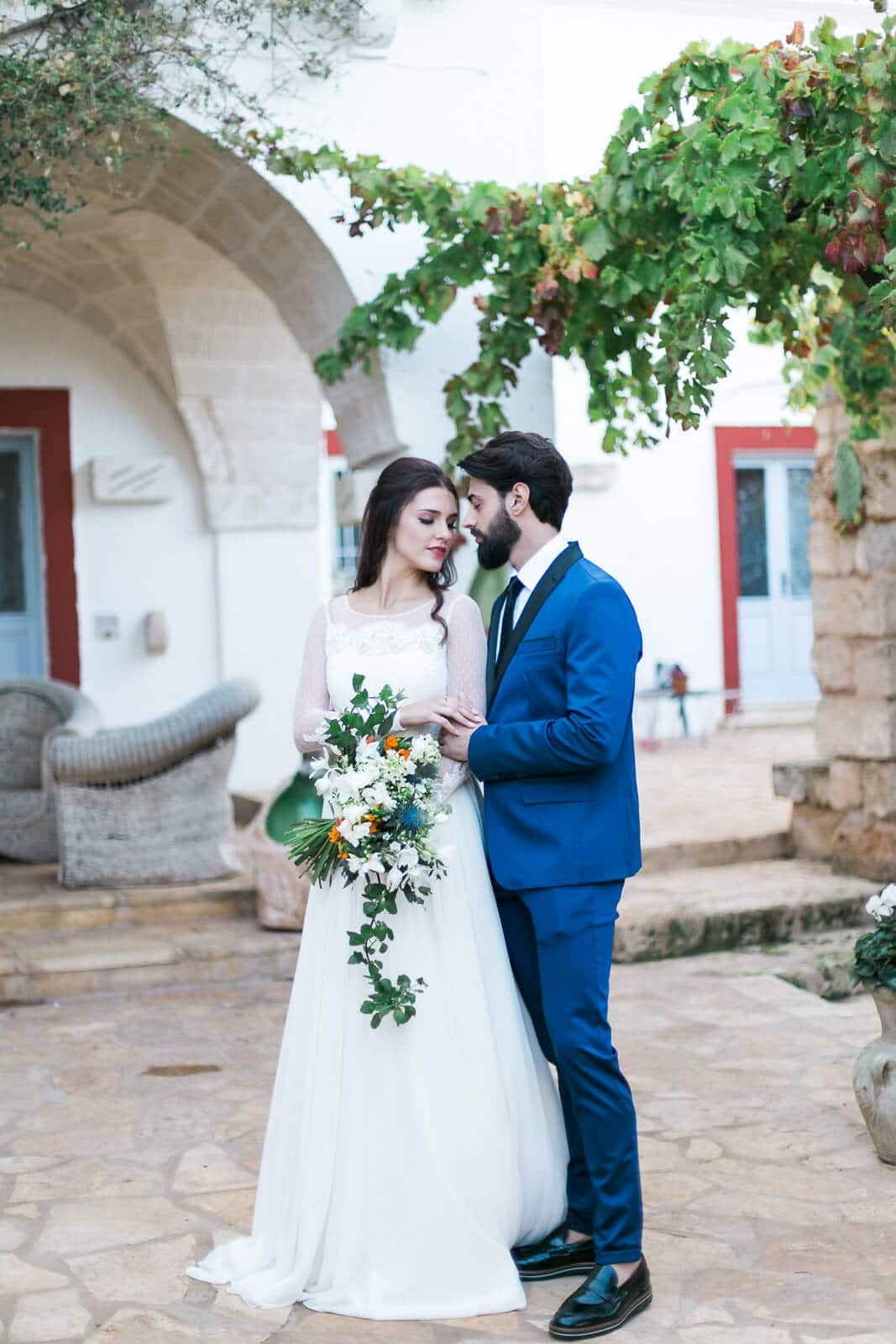 A bride and groom are posing for a picture in front of a building.