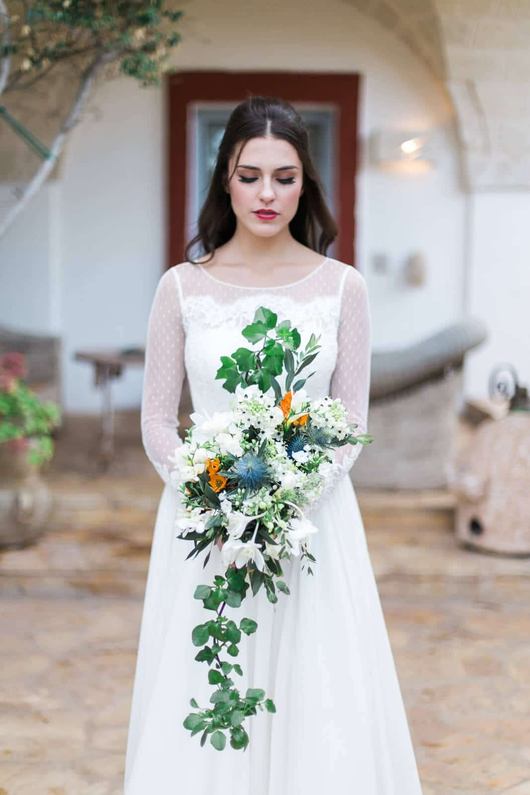 A bride in a white dress is holding a bouquet of flowers.