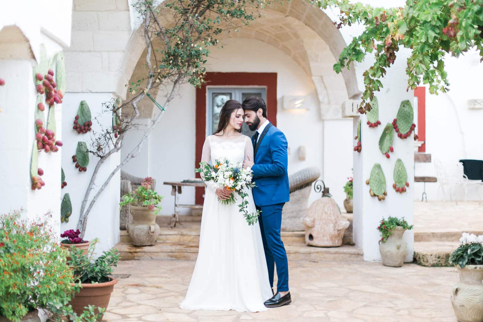 A bride and groom are posing for a picture in front of a building.