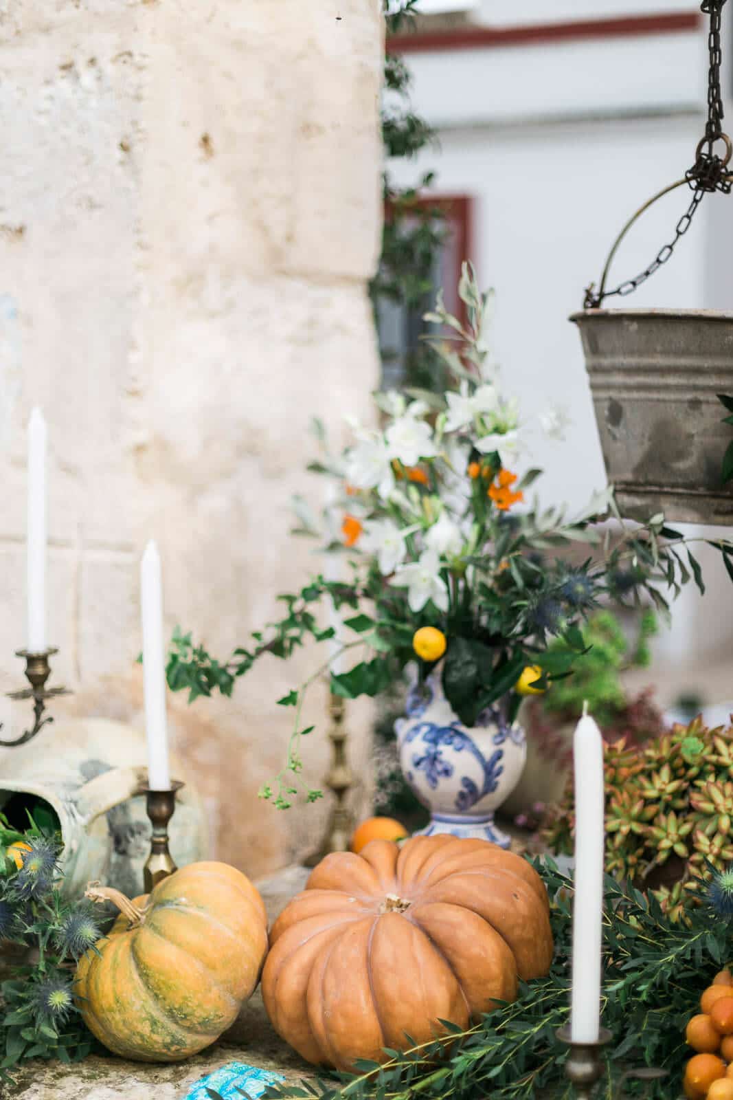 A table with pumpkins , candles and flowers on it.