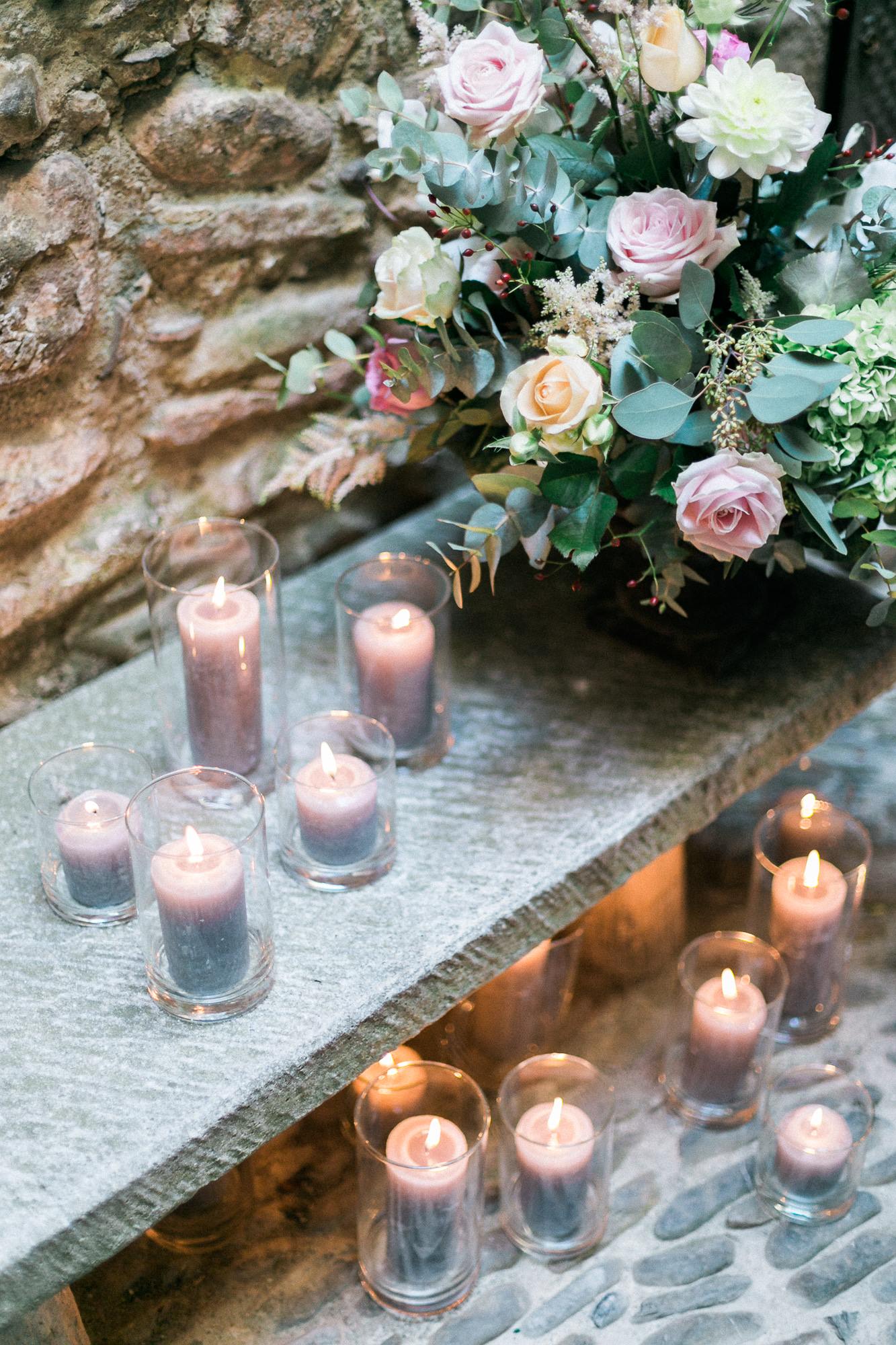 A table with candles and flowers on it.