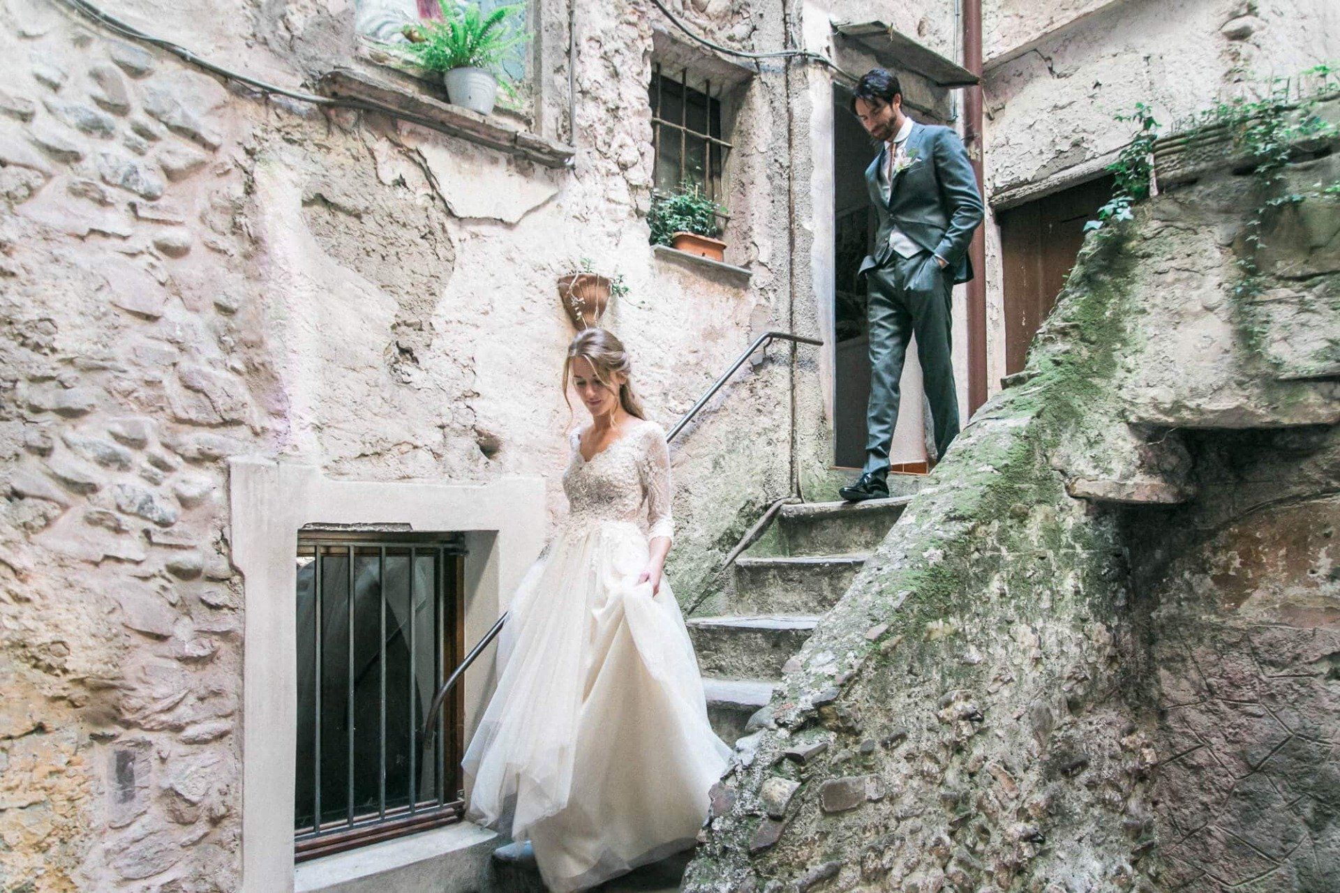 A bride and groom are standing next to each other on a set of stairs.