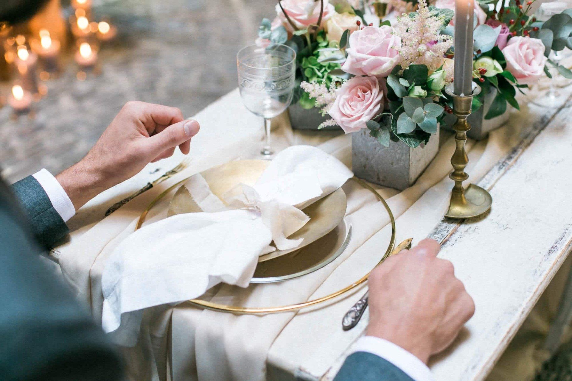 A man is setting a table for a wedding reception.