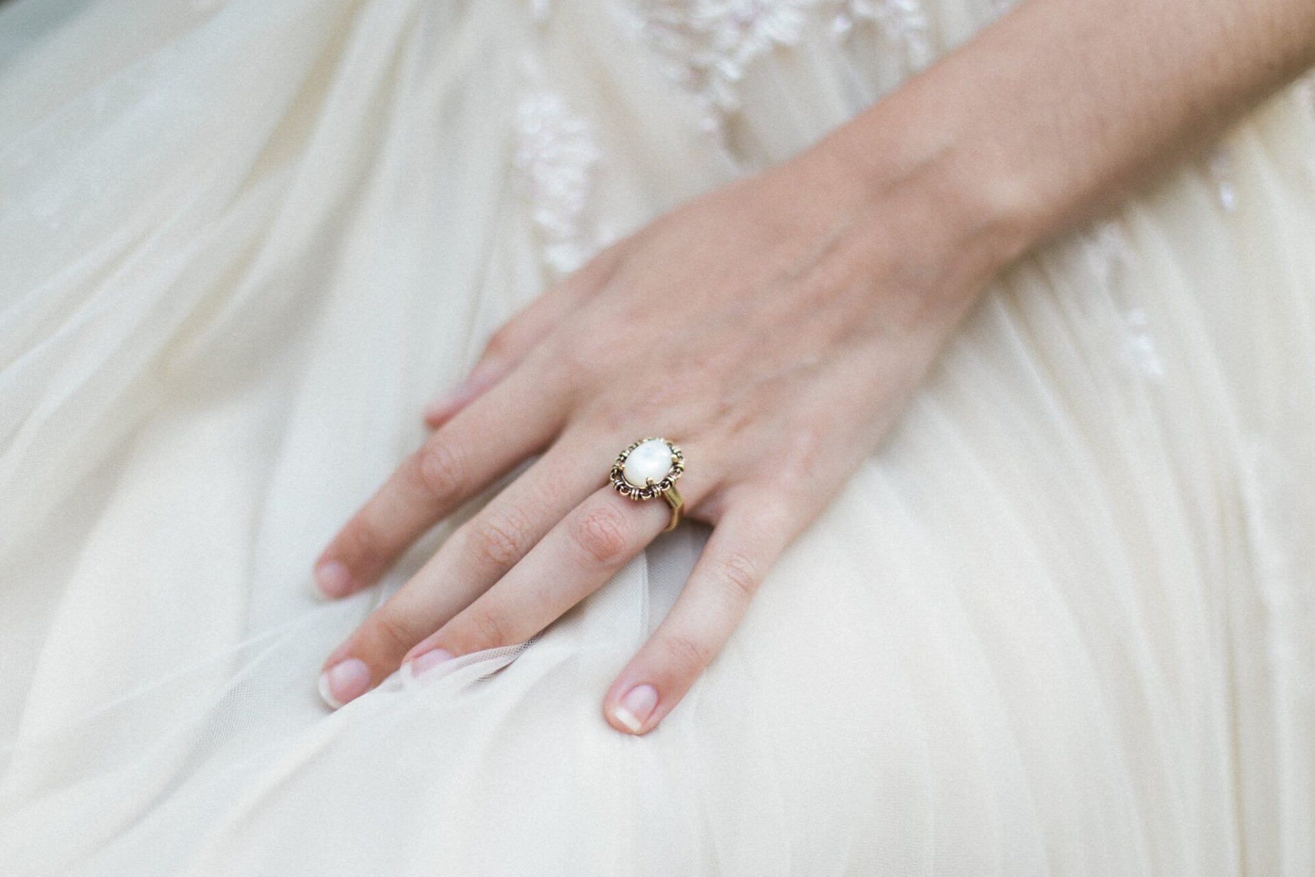 A close up of a woman 's hand with a ring on it.