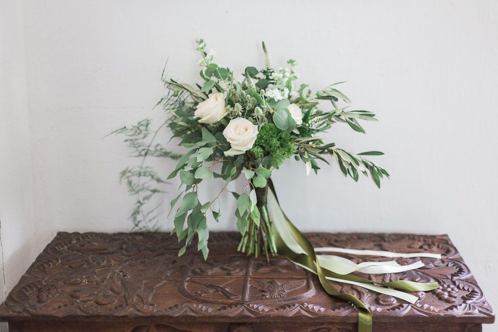 A bouquet of flowers is sitting on a wooden table.