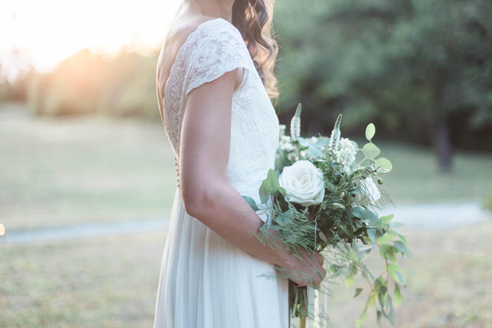 A bride in a white dress is holding a bouquet of flowers.