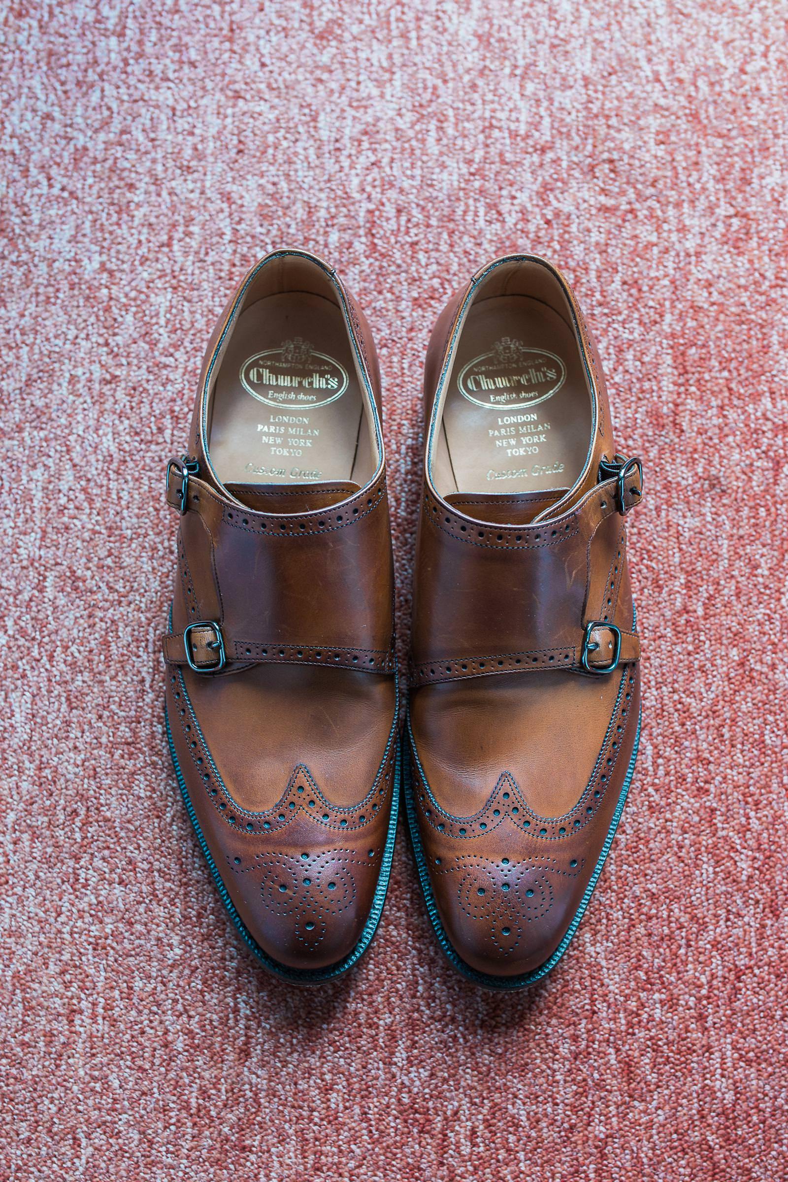 A pair of brown shoes are sitting on a red carpet.