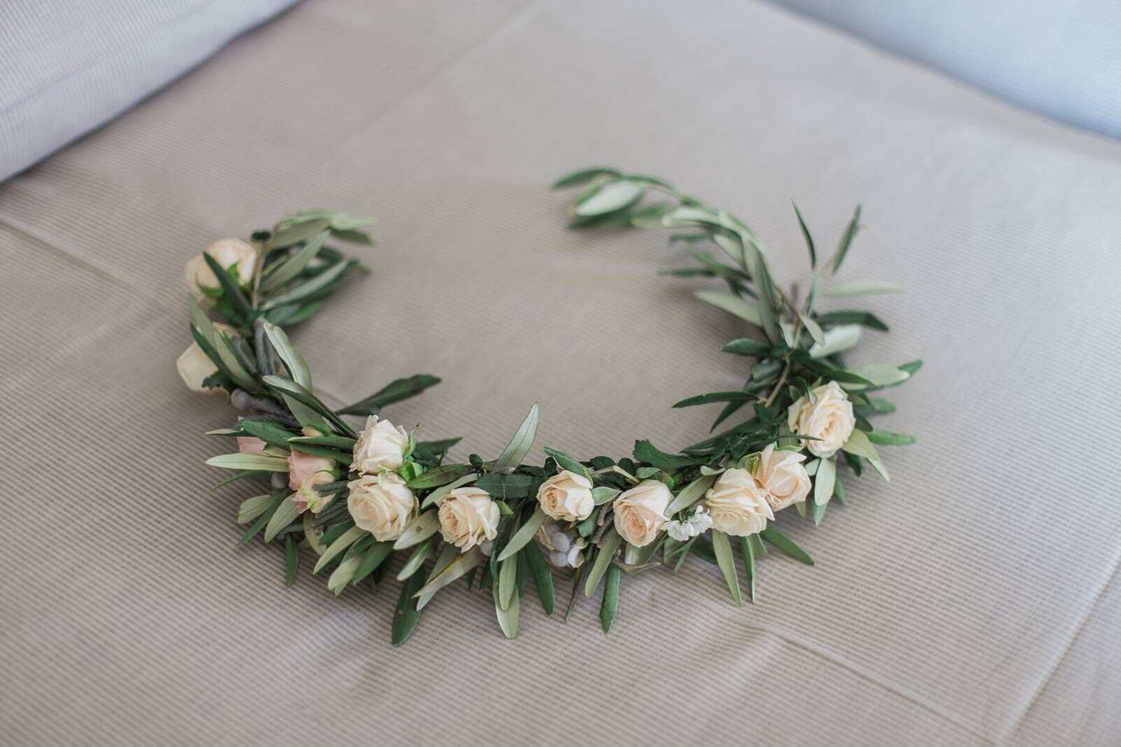 A flower crown is sitting on a bed.