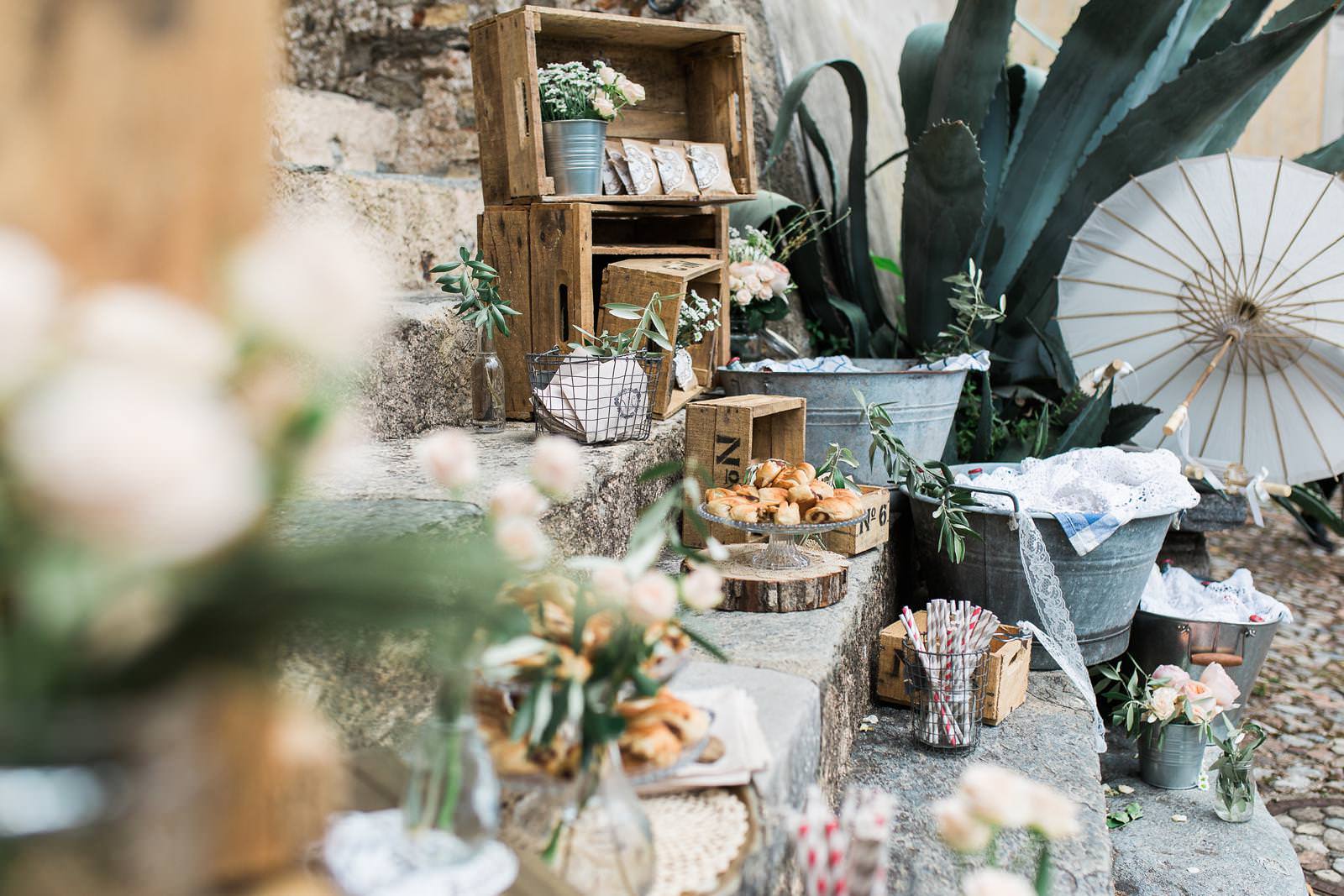 A table with flowers , umbrellas , and boxes on it.