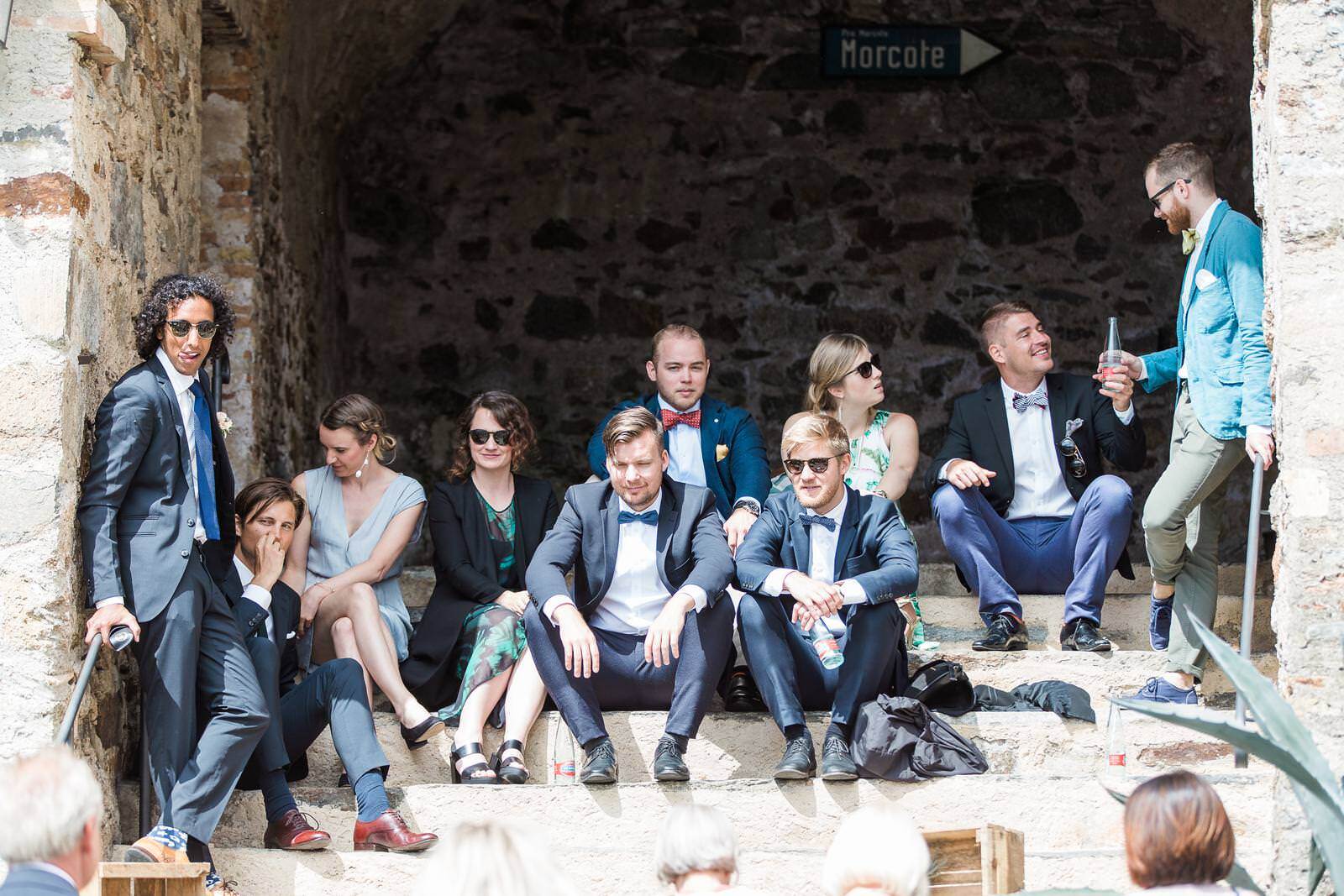 A group of people are sitting on the steps of a building.