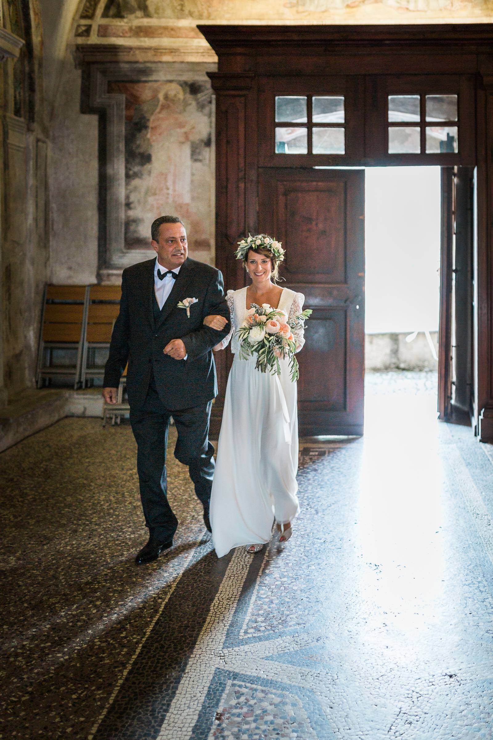 A bride and groom are walking into a church.