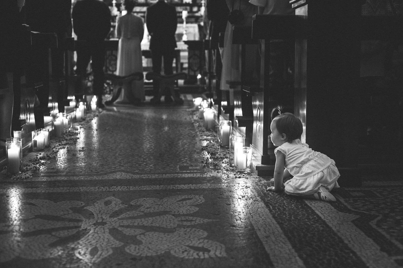 A little girl is crawling on the floor in a black and white photo.