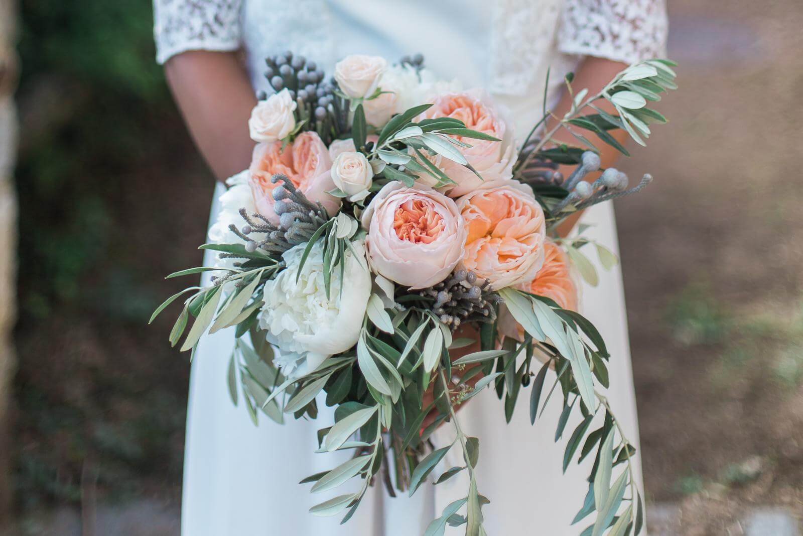 A bride in a white dress is holding a bouquet of flowers.