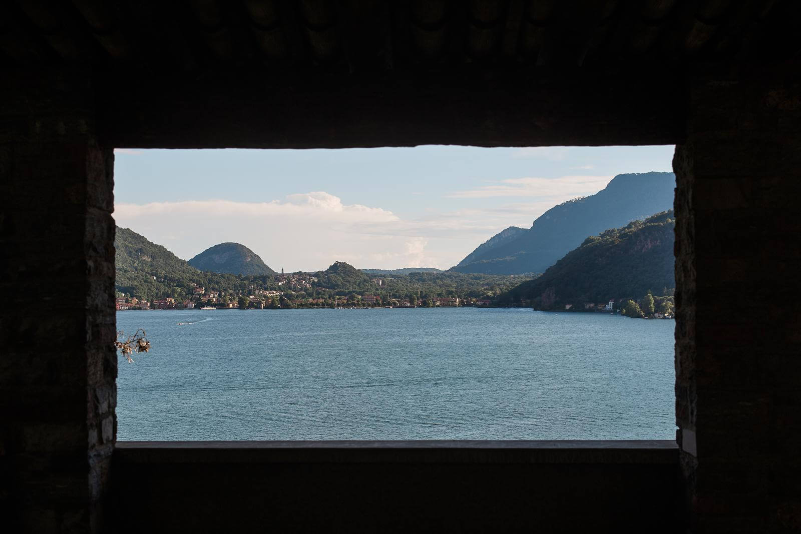 A view of a lake through a window with mountains in the background.