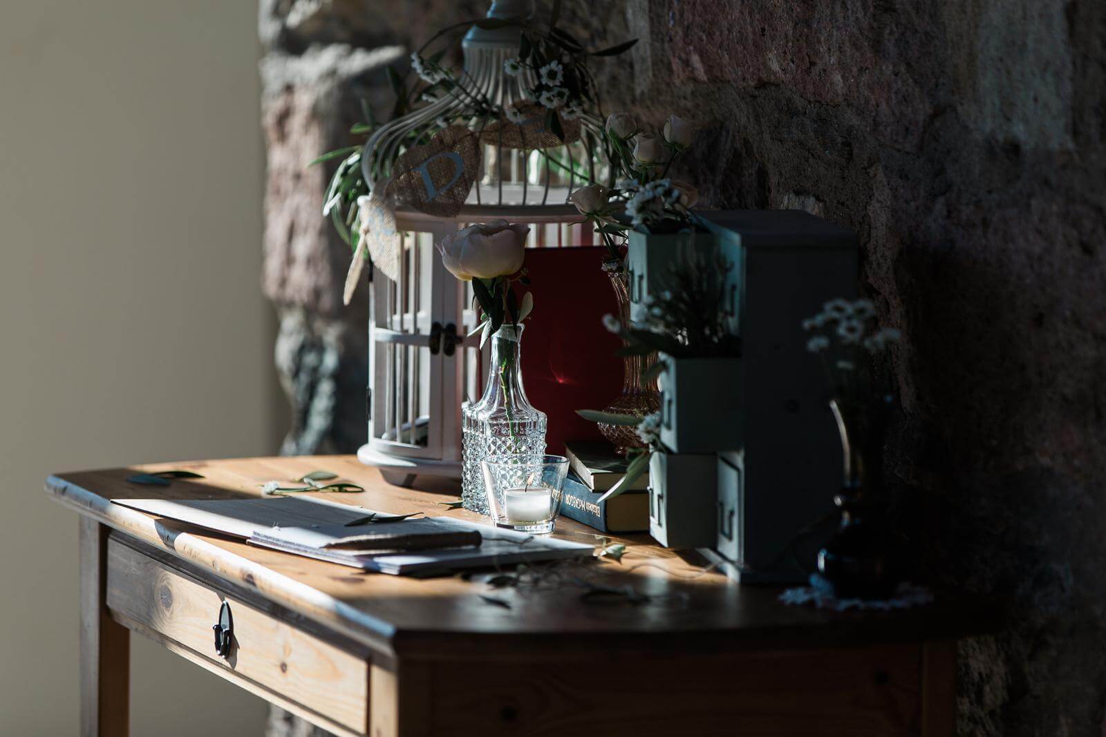A wooden table with a clock and a lantern on it.