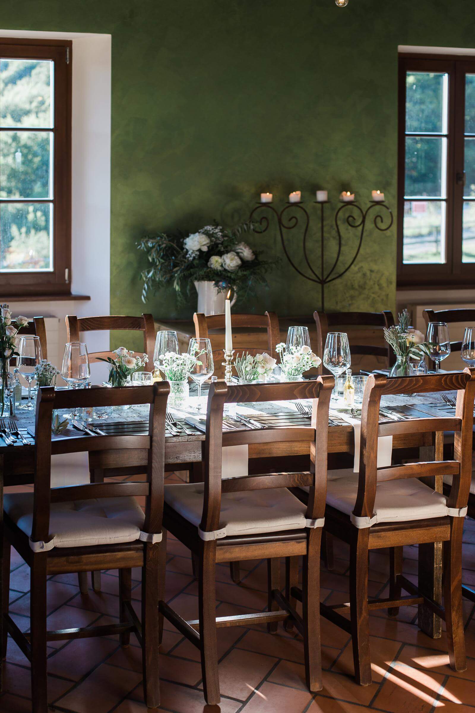 A dining room with a table and chairs and a green wall