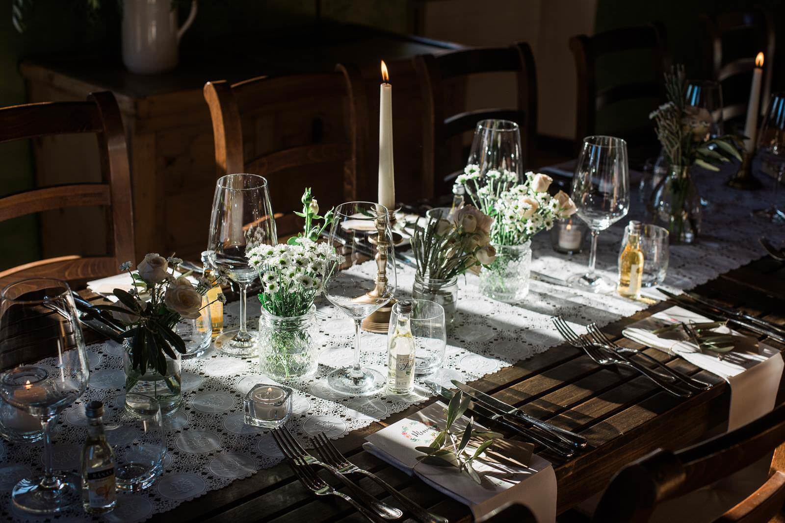 A table set for a dinner party with candles and flowers on it.