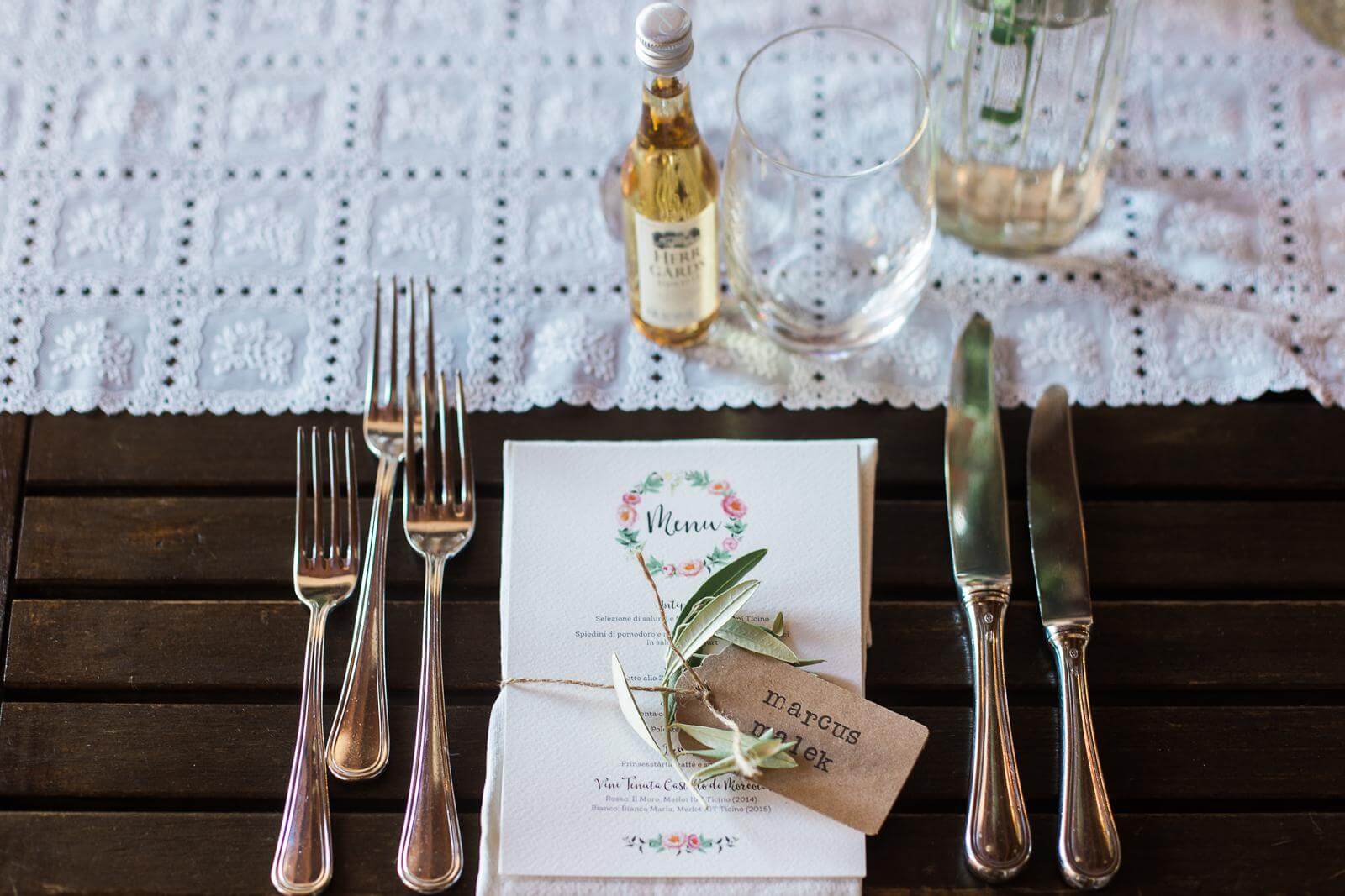 A wooden table with silverware and a menu on it.