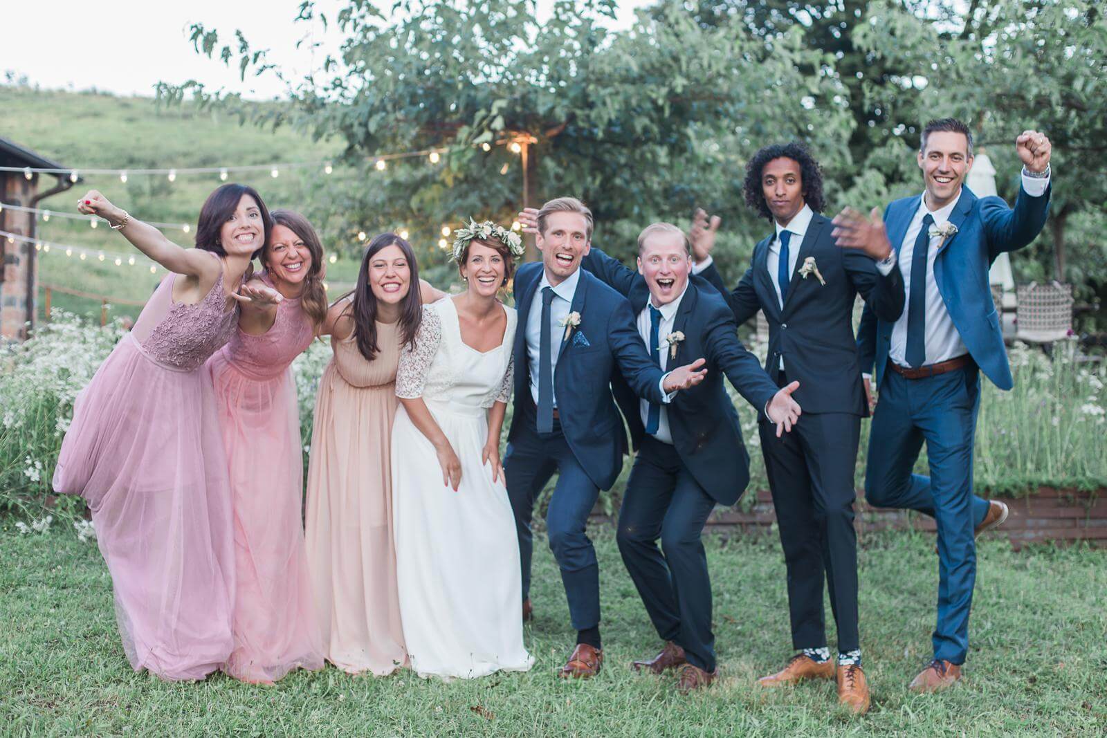 A bride and groom are posing for a picture with their wedding party.