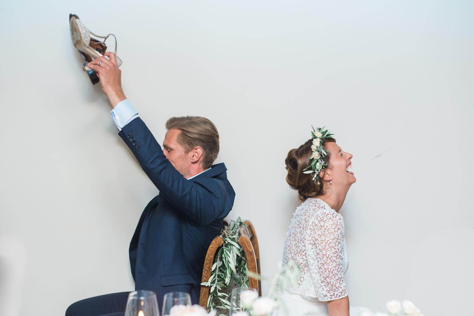 A bride and groom are sitting at a table with their backs to the camera.