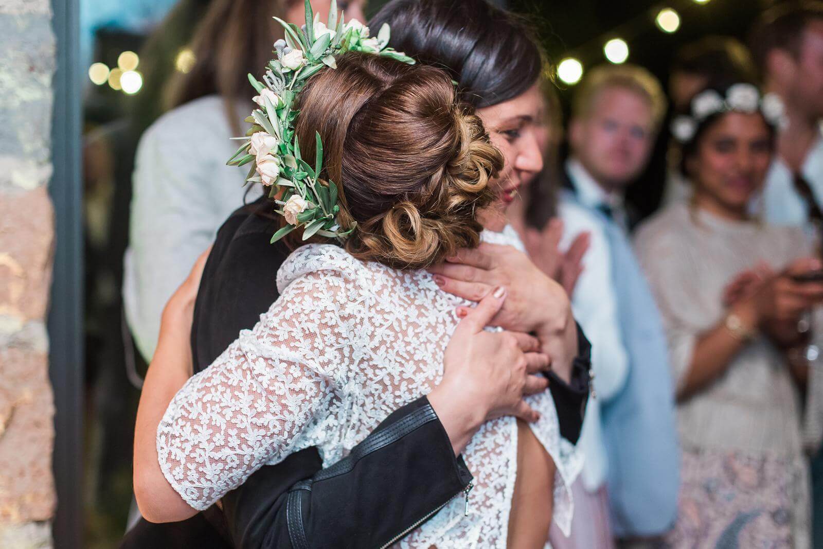 A bride and groom are hugging each other at their wedding reception.
