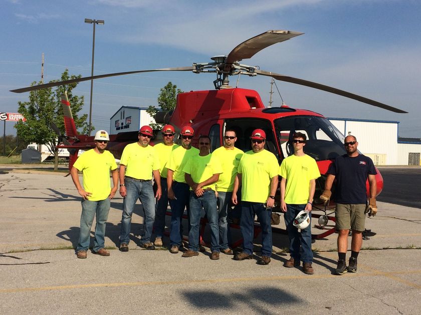 Construction Workers in Front of a Helicopter. Hulett Heating & Air Conditioning Company Team.