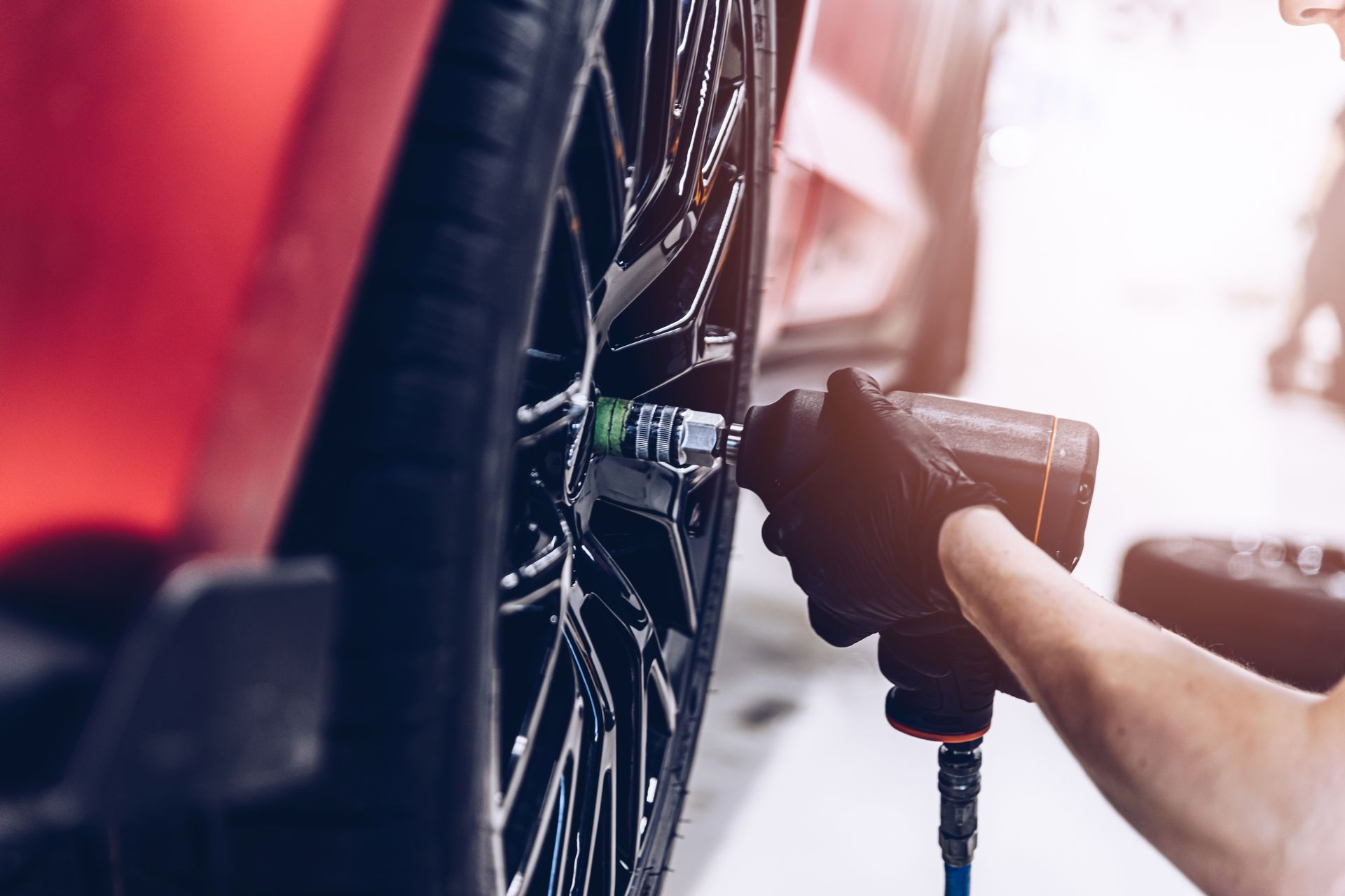 A person is changing a tire on a car with a wrench.