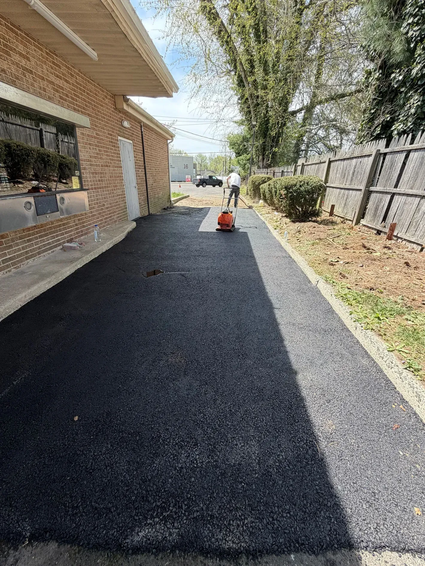 A driveway leading to a large house with a lot of windows