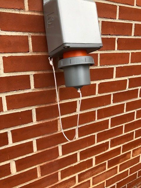 A brick wall with a gray box on it