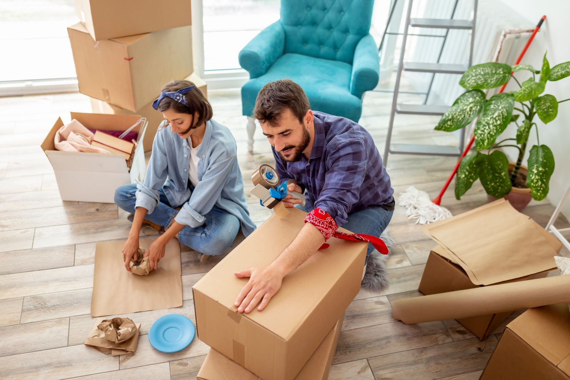Man and woman packing boxes in their living room