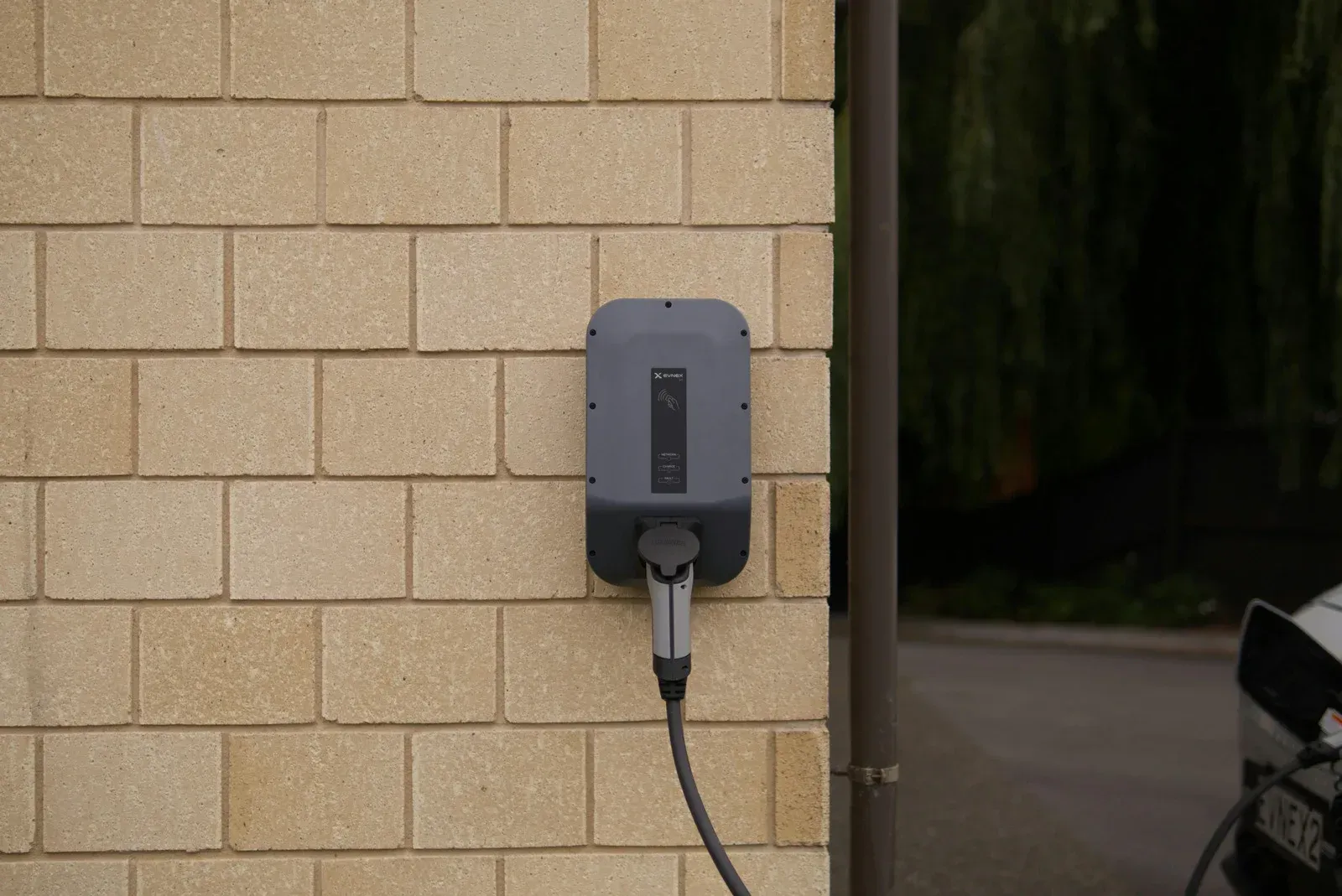 A close up of a charging station for electric cars against a blue sky.